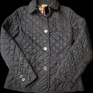 This is a navy blue Burberry quilted jacket with a signature check lining.